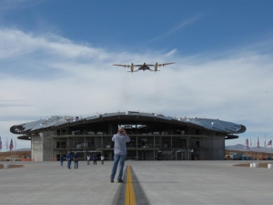 WhiteKnightTwo/SpaceShipTwo над незаконченным ангаром космопорта (space.com) WhiteKnightTwo/SpaceShipTwo над незаконченным ангаром космопорта (space.com)