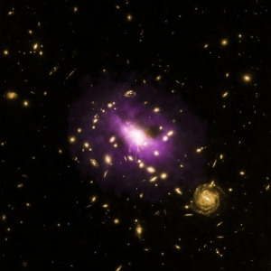 Скопление галактик в желтом оптическом свете и черная дыра, видимая в рентгеновском излучении (universetoday.com)