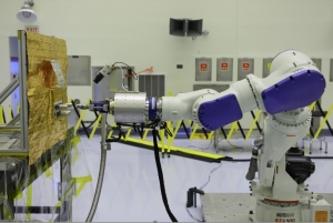 Робот, заправляющий макет спутника (phys.org)