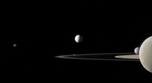 Энцелад (в центре), другие спутники Сатурна и его кольца (wikipedia.org)